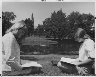 Coeds studying by the pond
