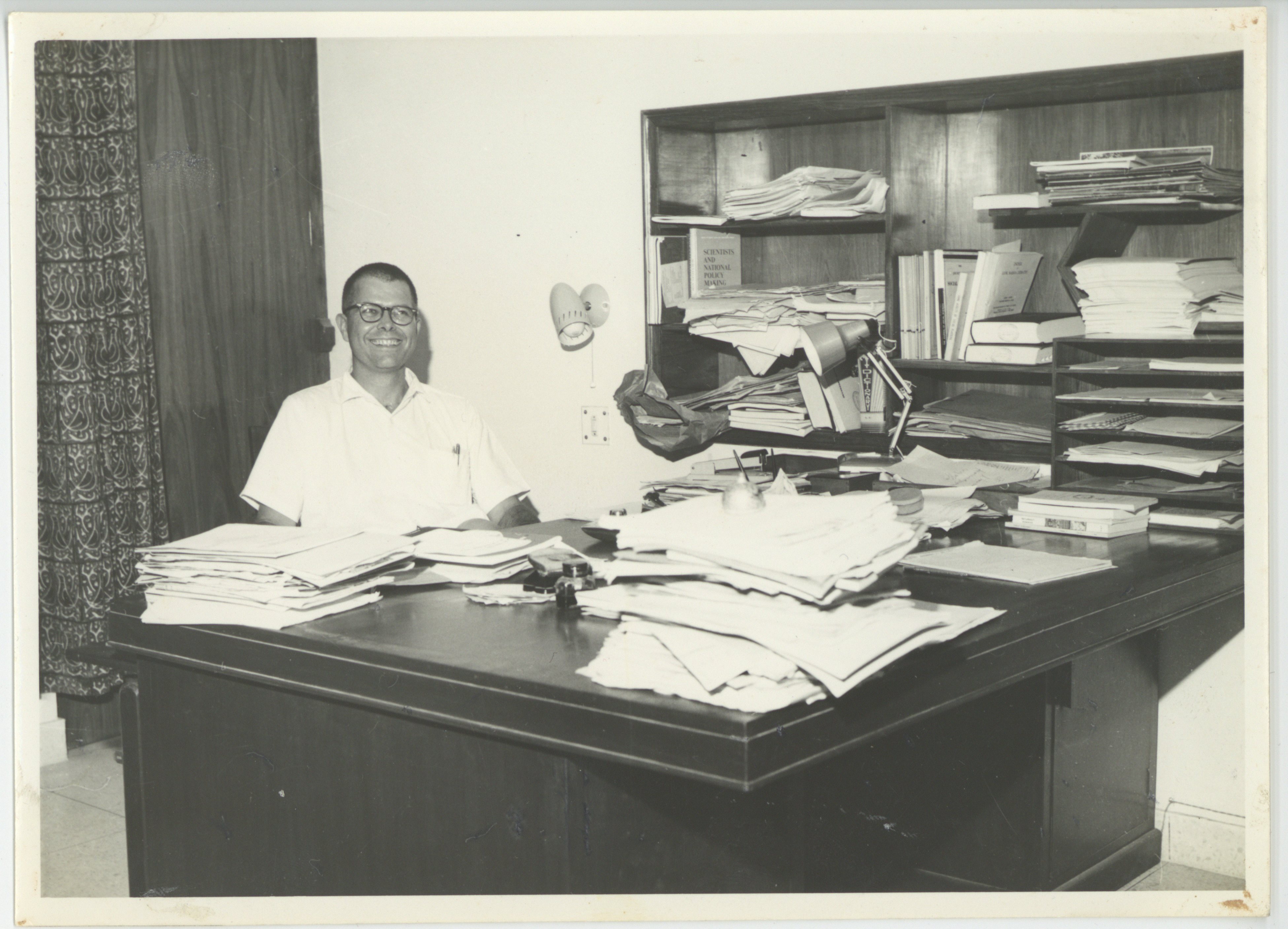 Depiction of Ward Morehouse at his desk in the Educational Resources Center, New Delhi, 1966
