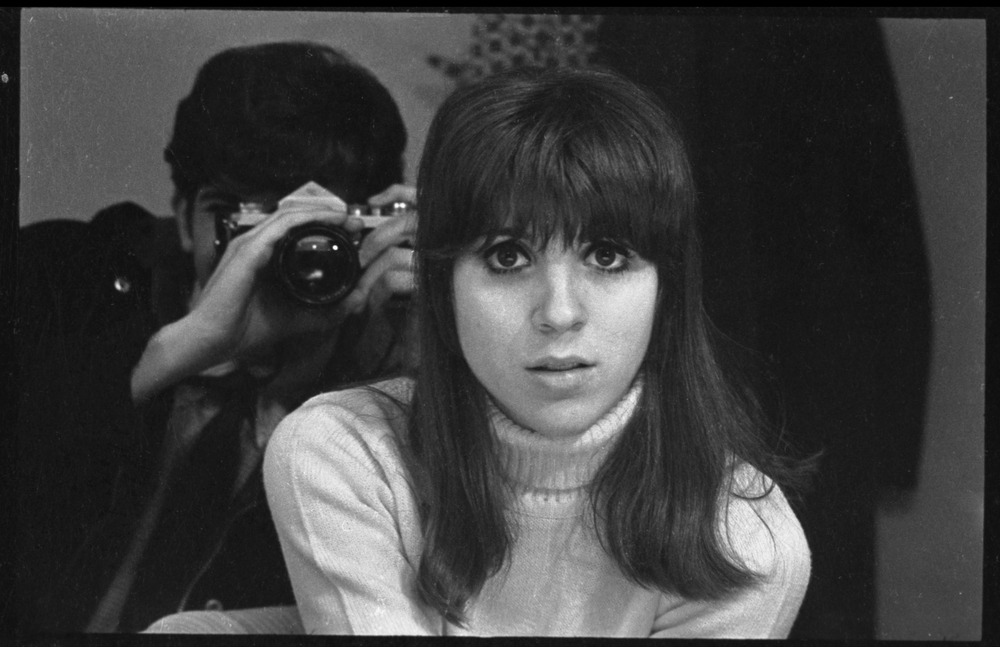 Depiction of Peter Simon in mirror photographing Jennie Blackton at the Bitter End Cafe, 1968