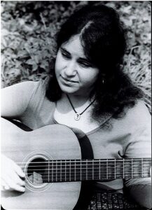 Judy Polan playing acoustic guitar