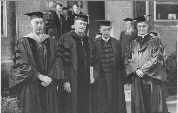 Ralph A. Van Meter standing outdoors with L. Carmichael, J.B. [Conant], and Rev. W.L. Keleher at Inauguration of Van Meter, October 1948